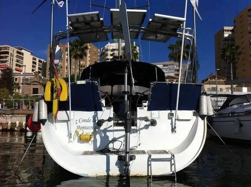 Sunset silhouette of a sailboat relying on its servo-auxiliary system